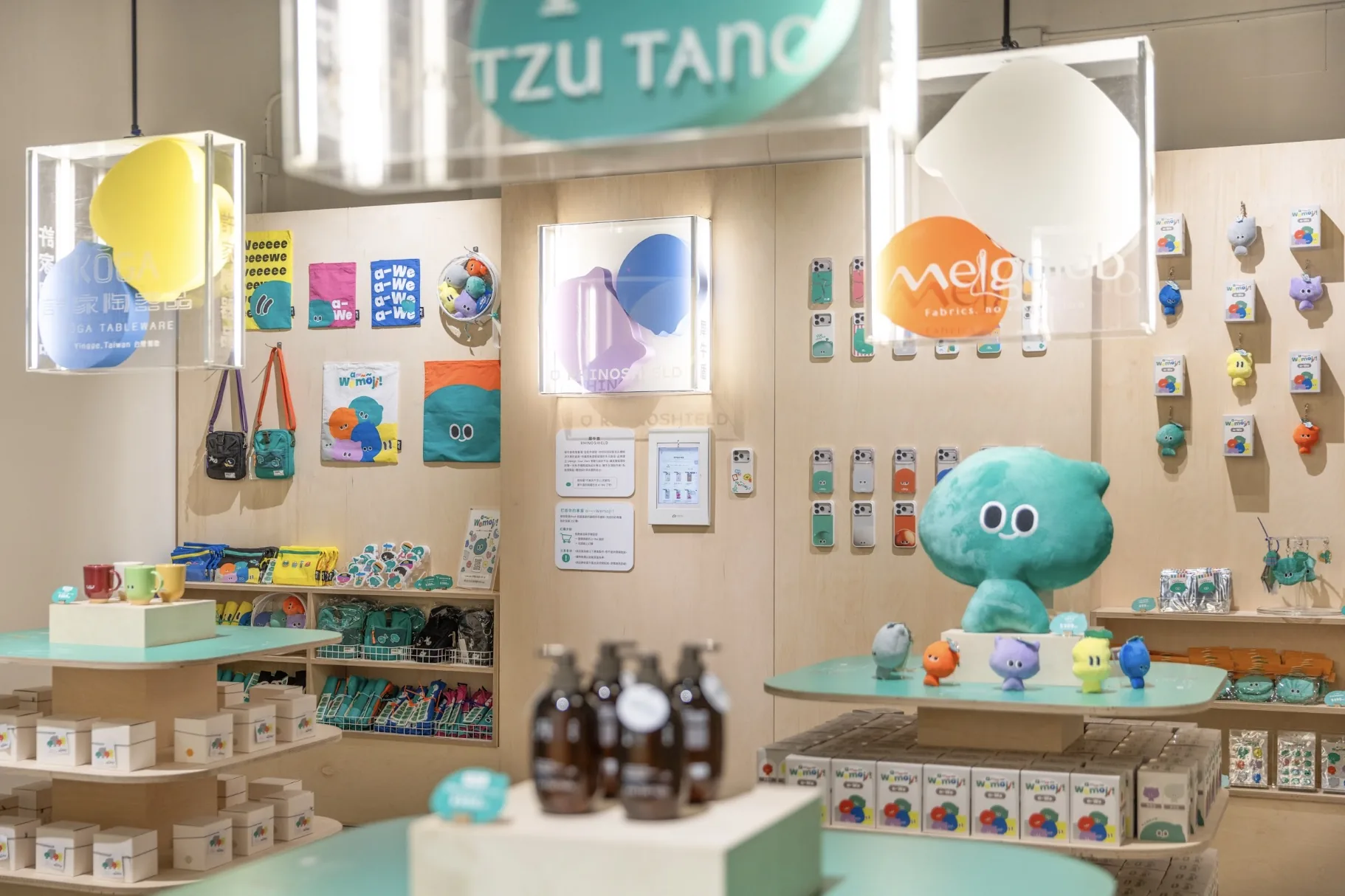 展覽商店內陳列的 a-We 聯名商品、手機殼與角色玩偶